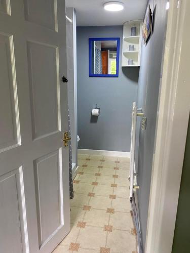 a hallway with a white door and a tile floor at The Coach House at Copper Hall in Leominster