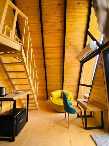 a room with a staircase and a yellow chair at Inn Martvili in Martvili