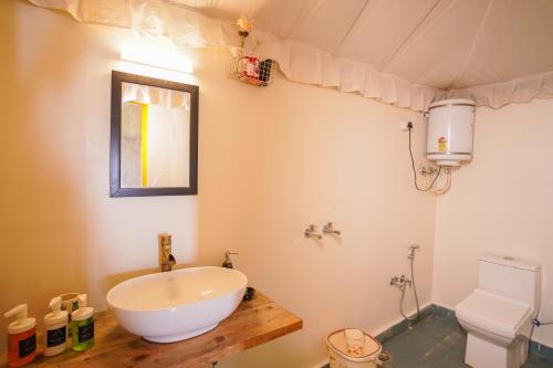 a bathroom with a sink and a toilet at Moksham Himalayan Campsite Pangot in Nainital