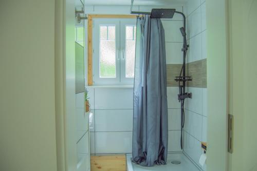 a shower with a blue shower curtain in a bathroom at Wellnessoase mitten in Triberg in Triberg