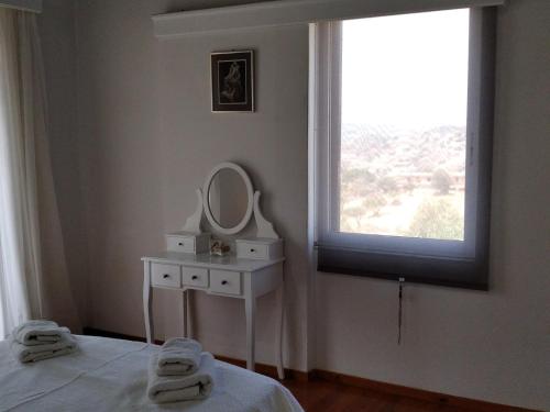 a bedroom with a bed and a mirror and a window at Jenny's Villa - Lagonissi in Kalívia Thorikoú