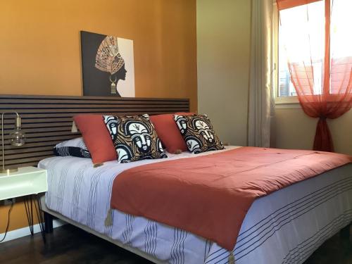 a bedroom with a bed with orange walls and a window at LE JARDIN D'HILAIRE in Entre-Deux