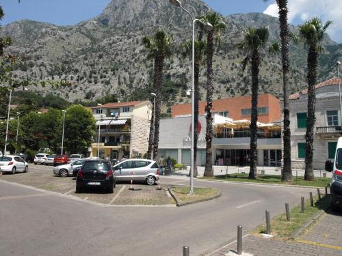 a parking lot with cars parked in front of a mountain at Apartment Nikolic Kotor in Kotor