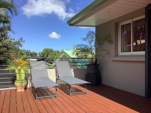 a deck with two chairs on a house at LE JARDIN D'HILAIRE in LʼEntre-Deux