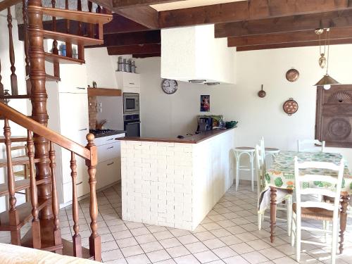 une cuisine et une salle à manger avec une table et des chaises dans l'établissement Maison confortable proche de Ploudalmézeau avec jardin, à Ploudalmézeau