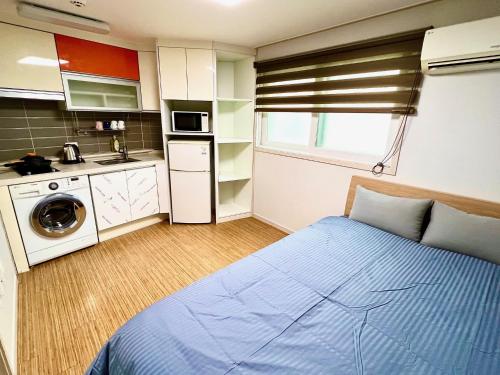 um pequeno quarto com uma cama e uma cozinha em BB Hongdae Line em Seul