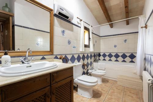 a bathroom with a sink and a toilet and a tub at Finca Sa Sort 454 in Inca