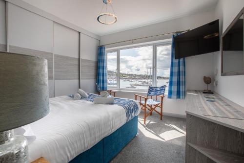 1 dormitorio con cama y ventana grande en Saltwhistle View- Beachside Luxury, Stunning Views en Teignmouth