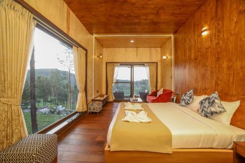 a bedroom with a large bed and a large window at Sri Vidhya Residency by Indo Stays in Kotagiri