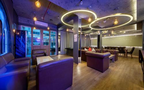 a restaurant with purple lighting and a bar at Qiu Hotel Sukhumvit SHA Plus in Bangkok