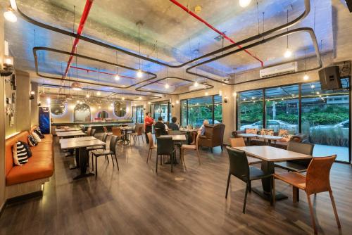 a restaurant with tables and chairs and people sitting at tables at Qiu Hotel Sukhumvit SHA Plus in Bangkok