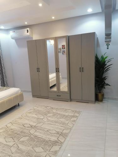1 dormitorio con armarios con espejos y alfombra en غرفة بمساحة واسعة حي الرمال en Riad