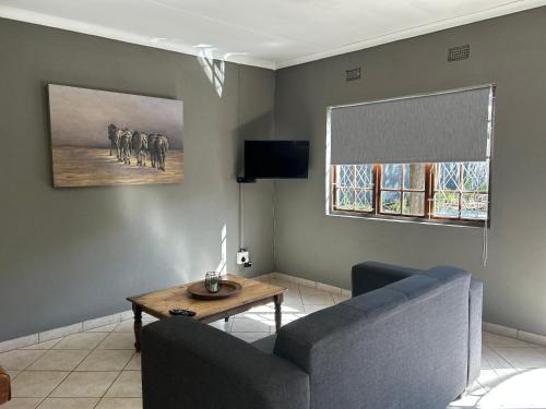 a living room with a couch and a table at Ama Zulu Guesthouse & Safaris in Hluhluwe