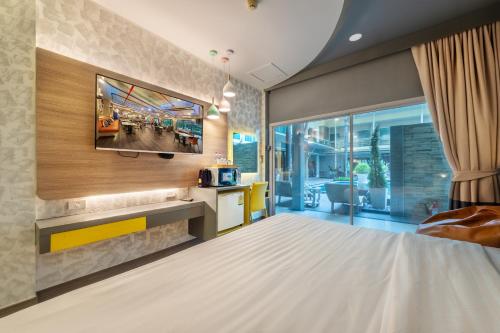 a bedroom with a tv on a wall at Qiu Hotel Sukhumvit SHA Plus in Bangkok