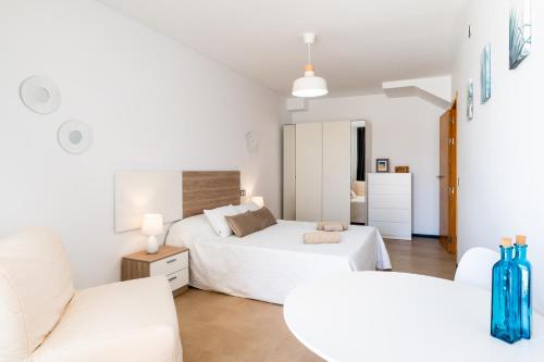 a white bedroom with two beds and a couch at Casa Lilia in Cotillo