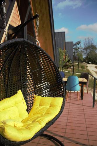 a bench with yellow pillows sitting on a porch at Inn Martvili in Martvili