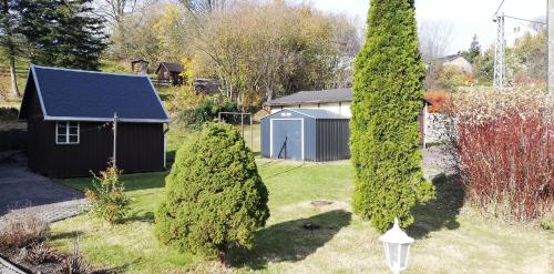 een tuin met een kleine schuur en een boom bij Ferienwohnung Sonnenblume in Pfaffroda