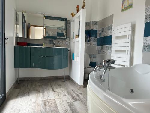 a bathroom with a tub and a sink and a toilet at le petit versaille in Saint-Paul-Trois-Châteaux