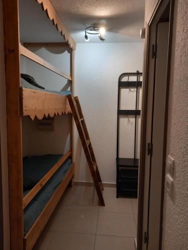 a room with two bunk beds and a doorway at Très agréable 2 pièces au pied des pistes in Valdeblore