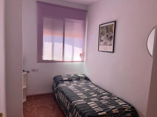 a bedroom with a bed in a room with a window at Apartamento a 200 metros de la playa de arena Les Cases en Xilxes - Castellón in Chilches