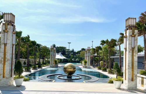 a pool at a resort with a fountain at Copacabana Beach Jomtien in Jomtien Beach