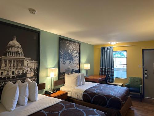 a hotel room with two beds and a picture of the us capitol at Super 8 by Wyndham WestEnd Alexandria,VA Washington DC Area in Alexandria