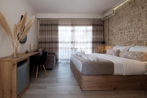 TEREZAS HOTEL في سيداري: غرفة نوم بسرير كبير وجدار حجري