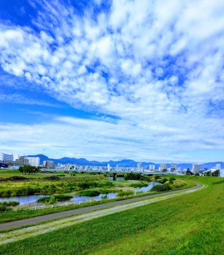 a road in the middle of a field with a river at aup178 in Sapporo