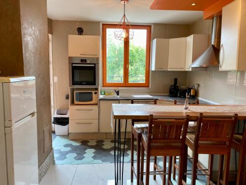 a kitchen with a table and some chairs in it at Maison et sa dépendance ss voisinage dans les vergers de Montmorency in Saint-Brice-sous-Forêt