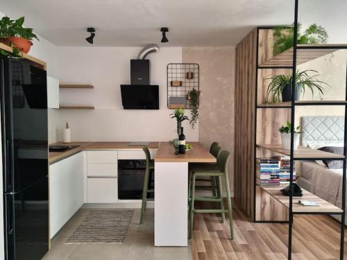 a kitchen with white cabinets and a table with chairs at Studio More Amore Dubrovnik in Dubrovnik