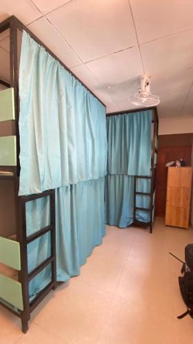 a room with blue curtains and two bunk beds at Happy Hammocks, Hiriketiya Beach - Sri Lanka in Hiriketiya