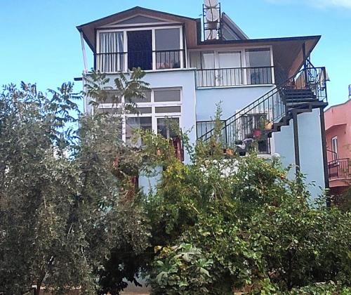 a white building with balconies and trees at nado in Kemer