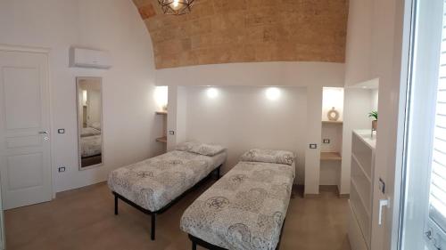 una camera con due letti e uno specchio di Villa Pescoluse a Marina di Pescoluse