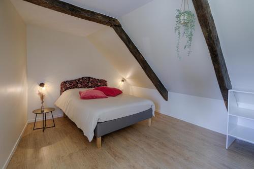 - une chambre avec un lit doté d'oreillers rouges dans l'établissement Duplex Le Louisels, à Bayeux