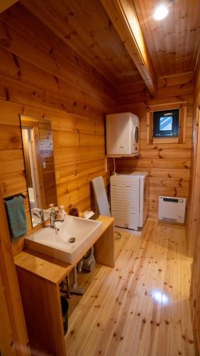 a bathroom with a sink in a wooden cabin at Wadano Gateway Suites & Apartments in Hakuba