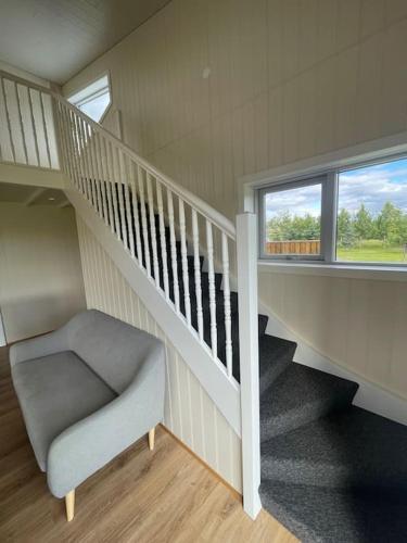 a room with a staircase and a chair and a window at Stunning house - amazing scenery in Hvolsvöllur