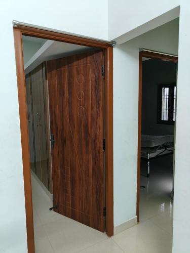 una puerta de madera en el medio de una habitación en Fiona Homestay en Chennai