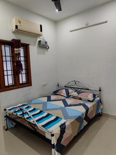 um quarto com uma cama num quarto em Fiona Homestay em Chennai