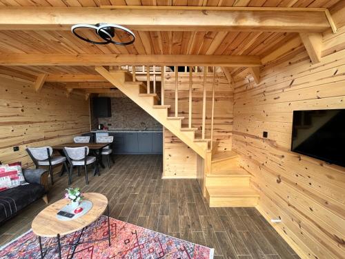una sala de estar con una escalera en una cabaña de madera en Masarona 2 nolu Dağ evi, en Çamlıhemşin