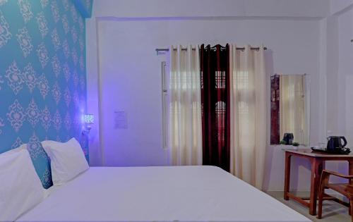 una camera da letto con un grande letto bianco e un tavolo di Hotel Surya Inn a Pura Raghunāth