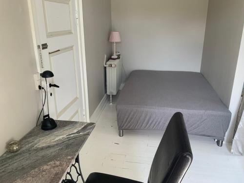 a bedroom with a bed and a desk and a chair at Den Gamle Apotekergaard in Høng