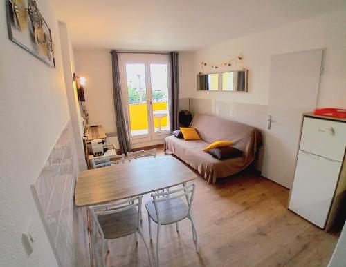 un petit salon avec une table et un canapé dans l'établissement T3 grande terrasse bord de mer, au Barcarès