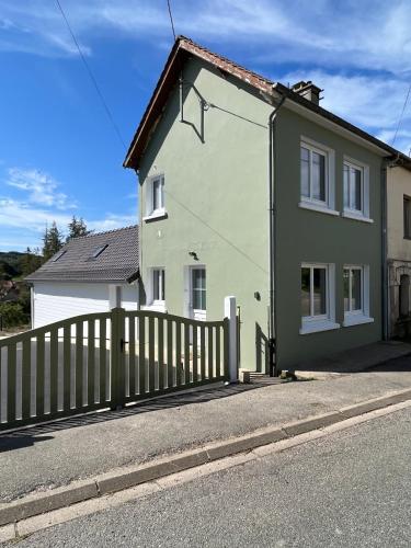 a white and green house with a fence at Maison in Enquin-sur-Baillons