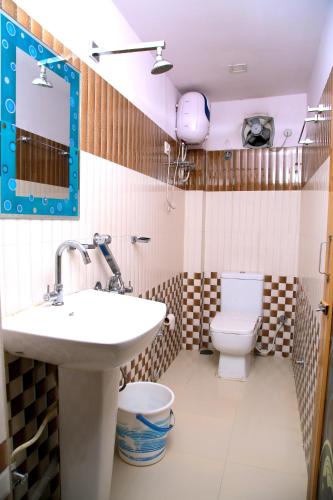 a bathroom with a sink and a toilet at Babul Hotel in Kolkata