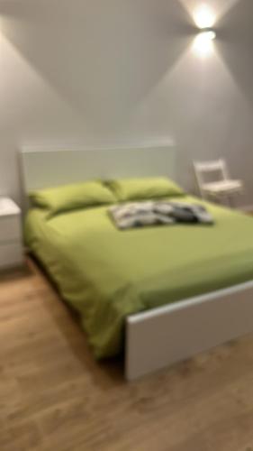 a bed with green sheets and pillows in a room at Centro Storico Caruggi 2min Acquario Pellicceria Superior Loft Palazzo Rolli in Genova