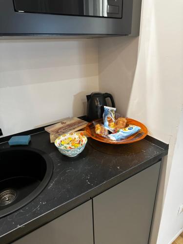 a kitchen counter with a plate of food and a sink at Centro Storico Caruggi 2min Acquario Pellicceria Superior Loft Palazzo Rolli in Genova