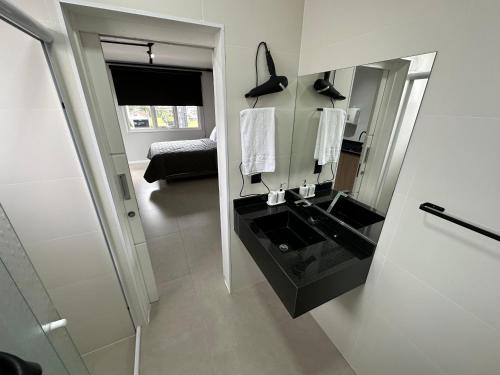 ein Bad mit einem schwarzen Waschbecken und einem Spiegel in der Unterkunft Studios 422 in Pomerode