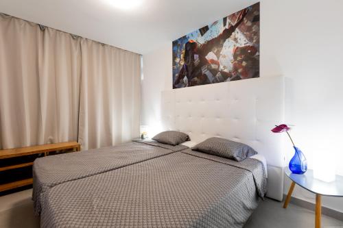 a bedroom with a bed and a painting on the wall at Apartment in Playa de las Americas in Playa de las Americas