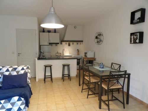 een woonkamer met een tafel en een keuken bij Gîtes Le Mas du Vieux Chêne in Salavas