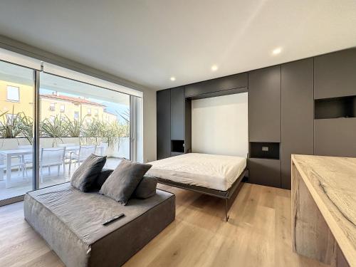 sypialnia z łóżkiem i dużym oknem w obiekcie AD Suite Apartment w mieście Riva del Garda
